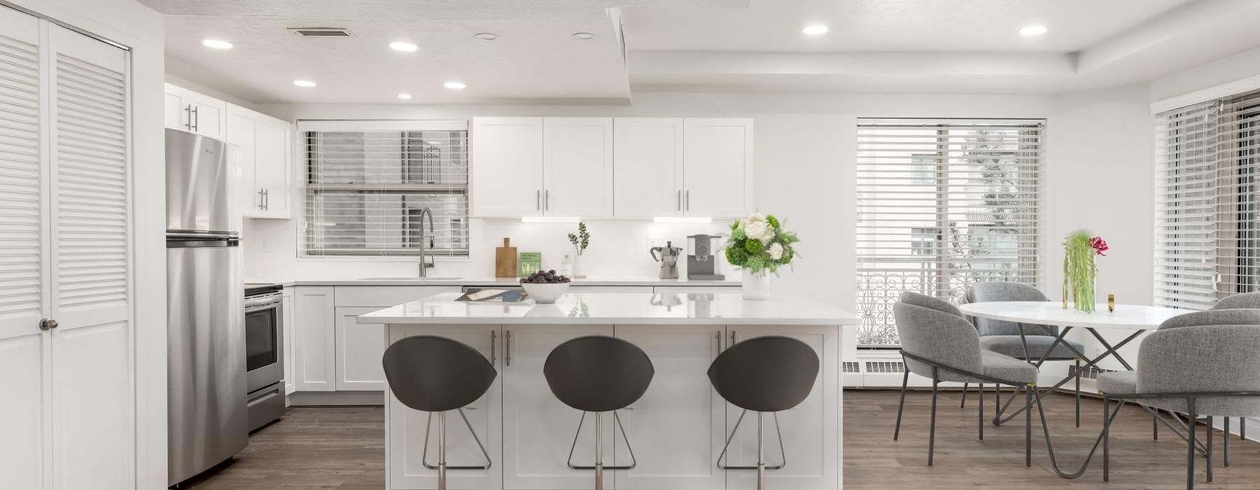a kitchen with white cabinets and a white table